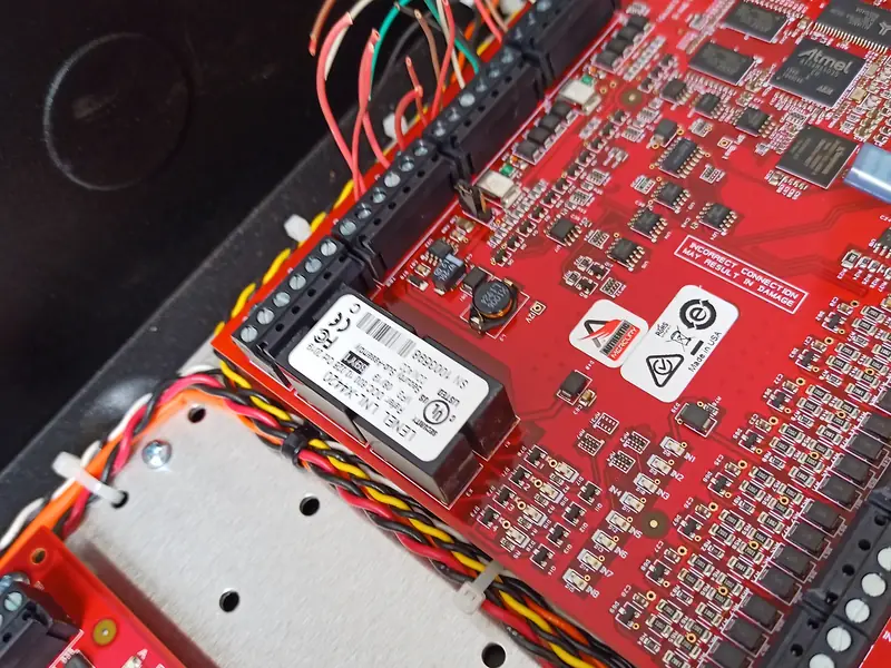 Close view of a controller board with twisted pairs tied along its edge.