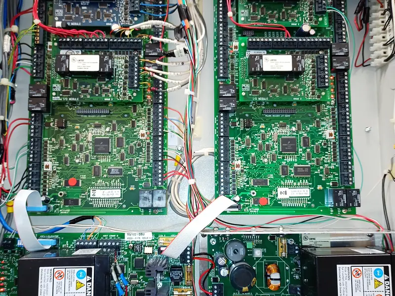 Four controller boards and two batteries in a large enclosure.