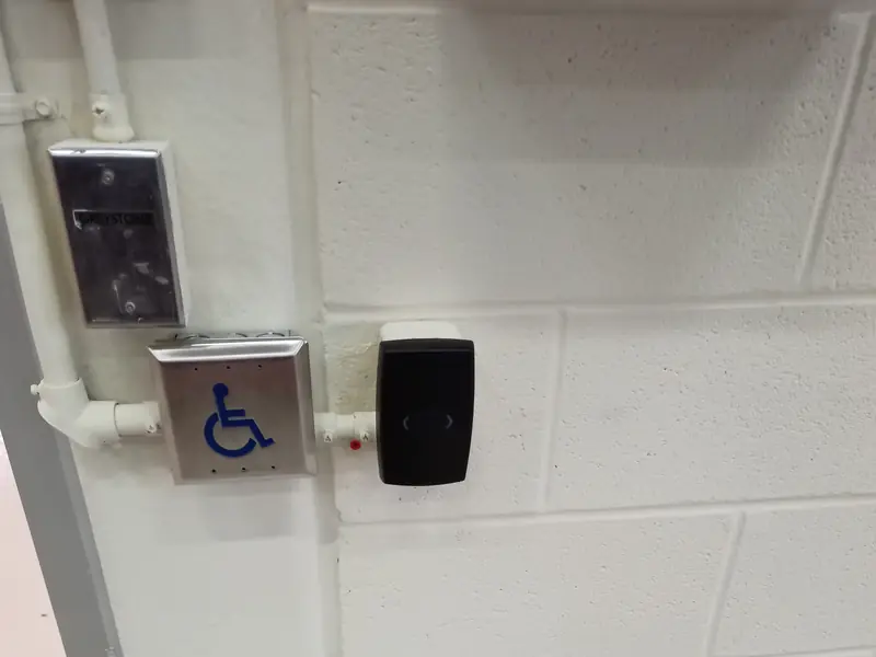 Card reader beside an accessible push button at a door.