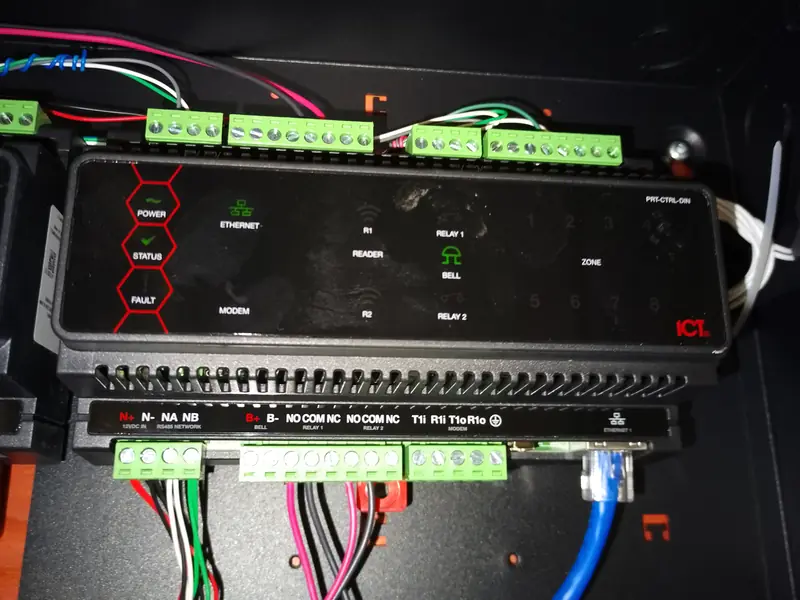 Coloured conductors landed on the terminal blocks of a controller module.